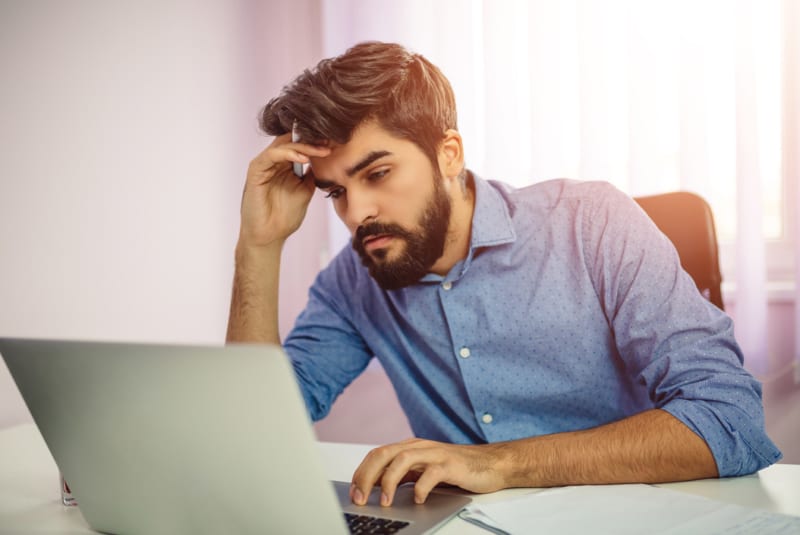 Googling my symptoms - Concerned businessman using laptop computer.