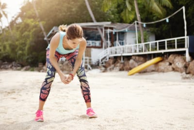 Physiotherapy and Summer Holidays - Girl stretching on the sand
